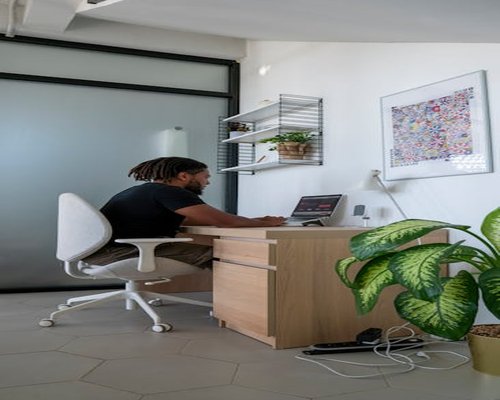 man working ergonomically at a bright modern desk